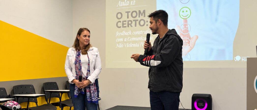 Aluno praticando uma apresentação ao microfone em aula na Vox Santana, com slide projetado